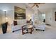Spacious living room featuring a white sofa set, a glass coffee table, and a ceiling fan with wood blades at 232 Southampton Ln # 259, Venice, FL 34293
