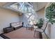 Inviting patio with a glass ceiling, comfortable seating, and lush greenery at 232 Southampton Ln # 259, Venice, FL 34293