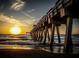 A long wooden pier stretches out into the ocean under a colorful sunset sky at 232 Southampton Ln # 259, Venice, FL 34293