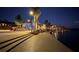 Scenic waterfront view at night showcasing a lit building, boardwalk, and calm water reflecting lights at 232 Southampton Ln # 259, Venice, FL 34293
