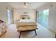 Bright bedroom with a cozy bed, stylish bench, and balcony access providing a serene retreat at 2380 N Beach Rd # 210, Englewood, FL 34223