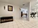 Bright hallway leading to a stylish kitchen and dining area, featuring neutral tiled floors and contemporary decor at 2380 N Beach Rd # 210, Englewood, FL 34223