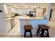 Bright kitchen featuring white cabinetry, stainless steel appliances, and a breakfast bar with seating for casual dining at 2380 N Beach Rd # 210, Englewood, FL 34223