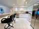 Bright kitchen with stainless steel appliances, white cabinetry, breakfast bar seating, and a modern, airy design at 2380 N Beach Rd # 210, Englewood, FL 34223