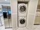 Convenient laundry closet next to stainless steel refrigerator features stacked washer and dryer, maximizing space at 2380 N Beach Rd # 210, Englewood, FL 34223