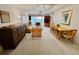 Open-concept living area with a dining table, comfortable seating, and sliding glass doors leading to the balcony at 2380 N Beach Rd # 210, Englewood, FL 34223