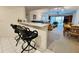 Open concept living space includes bar seating area, kitchen, dining area, and living room in a well lit layout at 2380 N Beach Rd # 210, Englewood, FL 34223