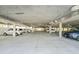 Interior parking garage area with concrete ceiling, support pillars, and multiple vehicles at 2380 N Beach Rd # 210, Englewood, FL 34223