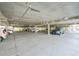 Parking garage area with concrete ceiling, support pillars, and multiple vehicles at 2380 N Beach Rd # 210, Englewood, FL 34223