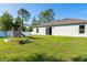 Lush backyard featuring a playset, bordered by a white fence, and surrounding trees at 2408 Bonanza Ln, North Port, FL 34286