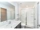 Bright bathroom featuring a shower with glass doors, white tile and gray vanity with a modern sink and faucet at 2408 Bonanza Ln, North Port, FL 34286