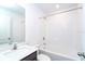 Bright bathroom with a white tub and shower combo, modern sink, gray vanity and chrome fixtures at 2408 Bonanza Ln, North Port, FL 34286