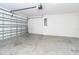Clean, spacious garage with a metal garage door, concrete floor, and bright overhead lighting at 2408 Bonanza Ln, North Port, FL 34286