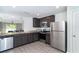 Modern kitchen with stainless steel appliances, granite countertops, and dark wood cabinets at 2408 Bonanza Ln, North Port, FL 34286