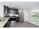 Modern kitchen featuring stainless steel appliances, dark wood cabinets and subway tile backsplash at 2408 Bonanza Ln, North Port, FL 34286