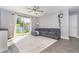 Open-concept living room with sliding glass doors and gray sectional sofa on light colored rug at 2408 Bonanza Ln, North Port, FL 34286