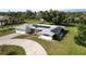 Stylish single-story home featuring a well-manicured lawn, circular driveway, and energy-efficient solar panels on the roof at 310 Green Dolphin Dr, Placida, FL 33946