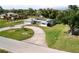 Charming single-story home boasts a circular driveway, lush lawn, and a roof equipped with modern solar panels at 310 Green Dolphin Dr, Placida, FL 33946