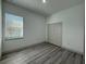 Bright bedroom with a window, closet, and modern wood-look flooring at 311 Yule St, Port Charlotte, FL 33953