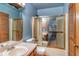Well-lit bathroom features a shower and bath combination with sliding door, along with a single sink with vanity at 3261 Rogue St, North Port, FL 34291