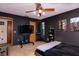 Sleek bedroom with dark walls, a ceiling fan, mounted TV, and an artistic atmosphere at 3261 Rogue St, North Port, FL 34291