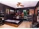 Modern bedroom with ceiling fan, featuring a platform bed with black bedding and an eclectic collection of decor at 3261 Rogue St, North Port, FL 34291