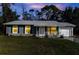 Charming single-story home with a manicured front lawn, a cozy porch, and an attached garage at 3261 Rogue St, North Port, FL 34291