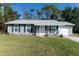 Charming single-story home featuring blue shutters and a cozy front porch perfect for relaxation at 3261 Rogue St, North Port, FL 34291