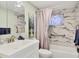 Bathroom features a marble tile shower, grab bars, and modern vanity at 39 1St Ave, Englewood, FL 34223