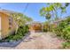 Large driveway with tropical trees and bushes with access to back gate and covered outdoor area at 39 1St Ave, Englewood, FL 34223