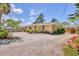 Charming home featuring a gravel yard with beautiful trees and flowering plants at 39 1St Ave, Englewood, FL 34223