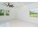 Minimalist bedroom with two windows offering a view of the greenery outside and tile floors at 398 Sunset N Rd, Rotonda West, FL 33947