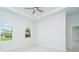 Bedroom with neutral color scheme, tray ceilings, two windows, and tiled floors at 398 Sunset N Rd, Rotonda West, FL 33947