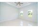 Bright bedroom featuring tiled floors, tray ceiling, and two large windows at 398 Sunset N Rd, Rotonda West, FL 33947