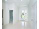 Bright entryway featuring pristine white tile floors, neutral walls, and a glass-paneled front door at 398 Sunset N Rd, Rotonda West, FL 33947