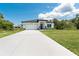 Lovely home with an inviting lawn, long driveway, and attached two car garage, under a bright blue sky at 398 Sunset N Rd, Rotonda West, FL 33947