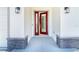 Stylish home showcasing a red front door flanked by stone columns and modern sconces at 398 Sunset N Rd, Rotonda West, FL 33947