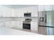 Modern kitchen with stainless steel appliances, quartz countertops and white cabinets at 398 Sunset N Rd, Rotonda West, FL 33947