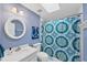 Colorful bathroom with a patterned shower curtain and a round mirror at 4219 Spire St, Port Charlotte, FL 33981