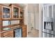 The bar features a cabinet with glass doors, mirrored backsplash, wine cooler, and stainless steel refrigerator at 4225 Fairway Dr, North Port, FL 34287