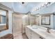 Bathroom features double sinks, walk-in shower with gold trim, and decorative mirrors and wallpaper at 4225 Fairway Dr, North Port, FL 34287