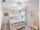This bedroom has light carpet, natural light, a ceiling fan, and charming décor that create a cozy and inviting space at 4225 Fairway Dr, North Port, FL 34287