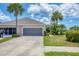 Charming single-story home featuring a spacious garage and lush landscaping with palm trees at 4225 Fairway Dr, North Port, FL 34287