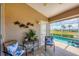 Cozy outdoor seating area on screened lanai with golf course and pool view at 4225 Fairway Dr, North Port, FL 34287