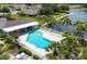 Aerial shot of a community pool showcasing lounge chairs, palm trees and lake views at 4225 Fairway Dr, North Port, FL 34287