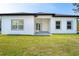 Exterior view of the back of the home, featuring a covered patio and well-manicured lawn at 482 Sunset N Rd, Rotonda West, FL 33947