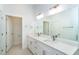 Bathroom featuring dual sinks, a large mirror, white cabinetry and modern fixtures at 482 Sunset N Rd, Rotonda West, FL 33947