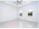 Bright, empty bedroom with tile floors and impact windows showcasing the backyard view at 482 Sunset N Rd, Rotonda West, FL 33947