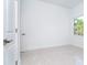 Bright bedroom with light tile floor, white walls, and a window to the green outdoors at 482 Sunset N Rd, Rotonda West, FL 33947