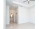 Spacious bedroom with tray ceiling, tile flooring, and an ensuite bathroom at 482 Sunset N Rd, Rotonda West, FL 33947